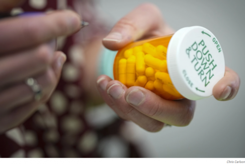Person holding a pharmacy bottle of pills